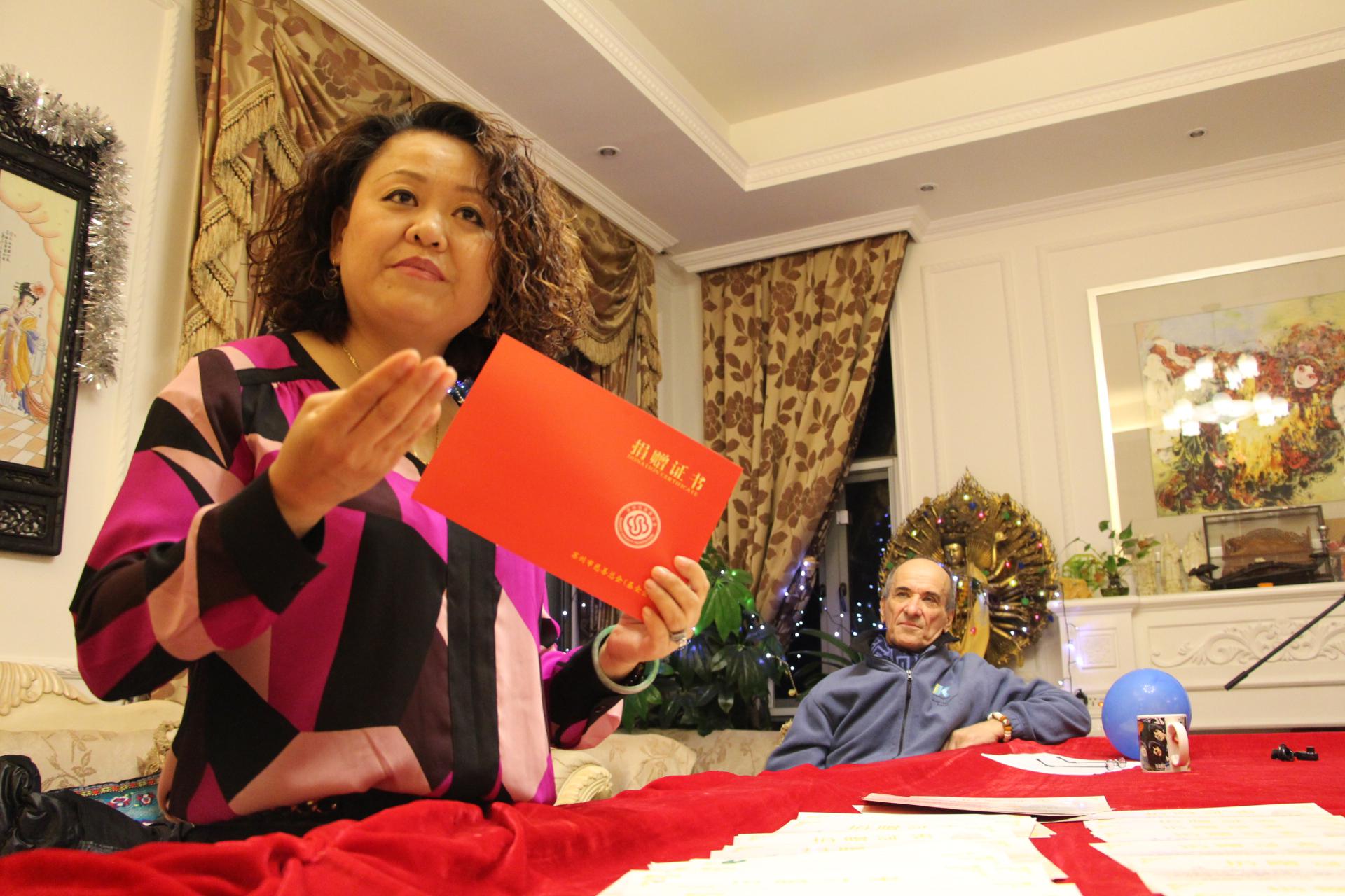 汤崇雁展示她的捐赠证书。