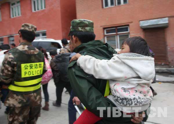 公安边防战士背着撤离的孩子