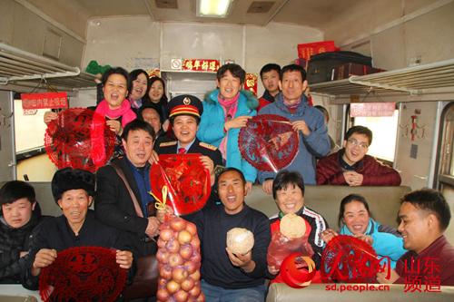 列车长赵新华和乘客们举行了“联欢会”，共度列车上的“小年”。（摄影：宋翠）