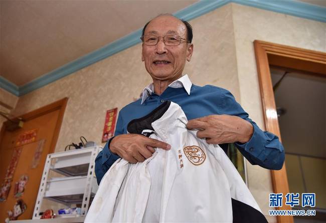 陈志棠向记者展示他的太极拳服装（5月24日摄）。新华社发（王玺摄）