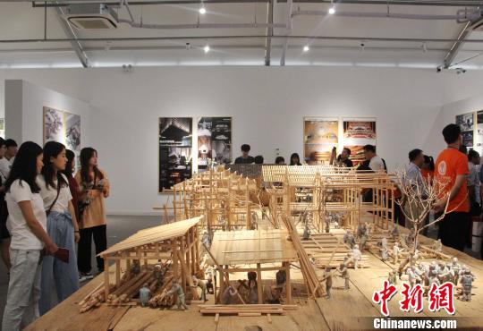 图为学生们在现场围观建筑艺术设计展区内的《大木匠造》作品。　赵晓 摄