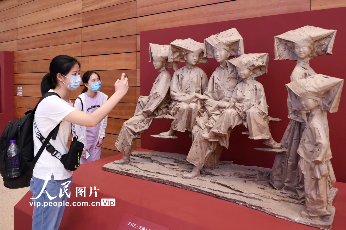 2021年6月19日，观众在国博用手机拍摄刘超2019年创作的雕塑作品《三月三·云端上的笑声》。
